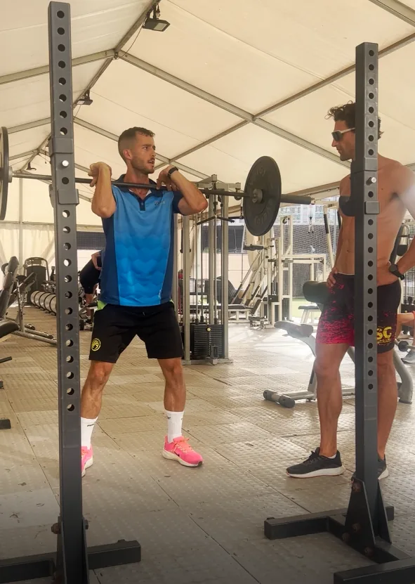 Deportista entrenando fuerza con barra en el gimnasio